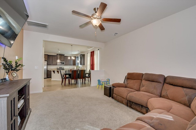 living room with light carpet and ceiling fan