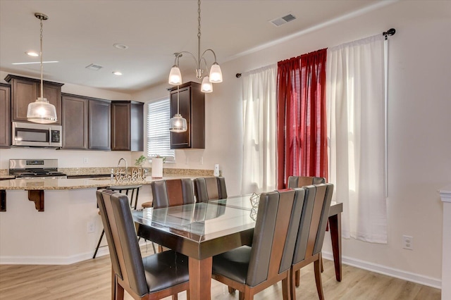 dining area with a chandelier and light hardwood / wood-style floors