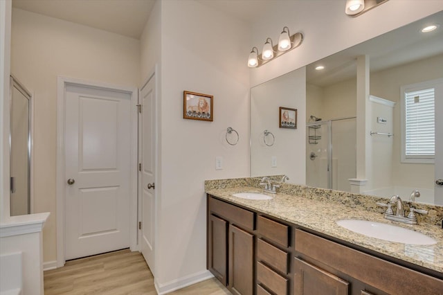 bathroom with vanity, wood-type flooring, and a shower with door