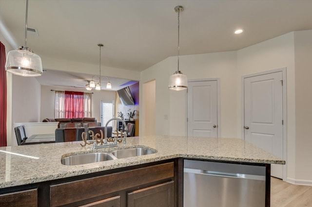 kitchen featuring light stone counters, ceiling fan, sink, decorative light fixtures, and dishwasher