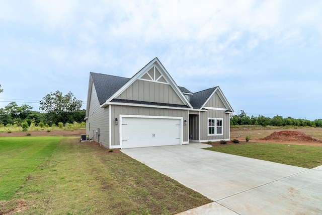 view of front of house featuring central air condition unit, a front yard, and a garage