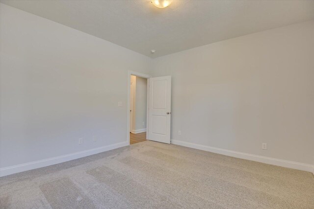 empty room featuring light carpet and a textured ceiling