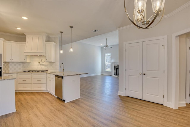 kitchen featuring sink, white cabinets, custom exhaust hood, stainless steel dishwasher, and kitchen peninsula