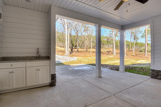 view of patio with ceiling fan and sink