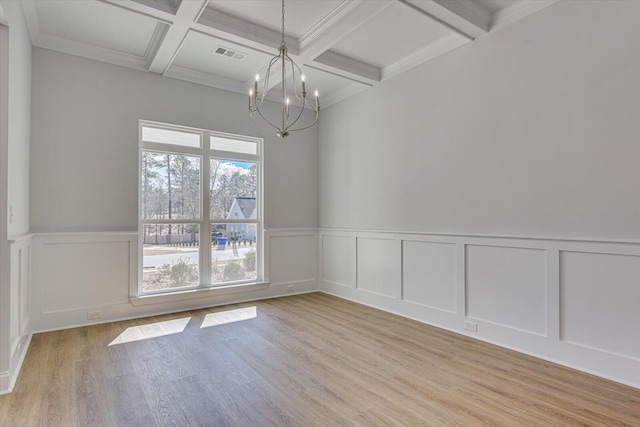 unfurnished room with coffered ceiling, a notable chandelier, beam ceiling, and light hardwood / wood-style flooring