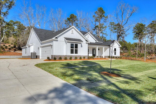 view of property exterior with central AC unit, a garage, and a yard