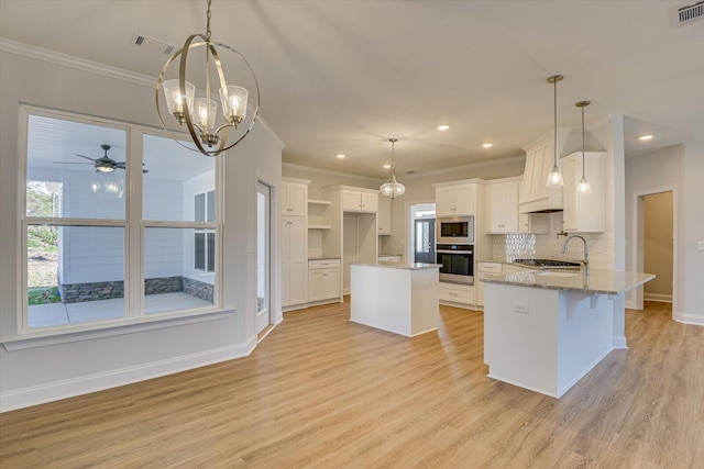 kitchen with white cabinetry, hanging light fixtures, plenty of natural light, stainless steel appliances, and light stone countertops