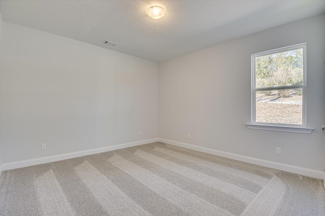 carpeted spare room featuring a textured ceiling