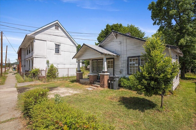 view of front of property featuring covered porch and a front yard