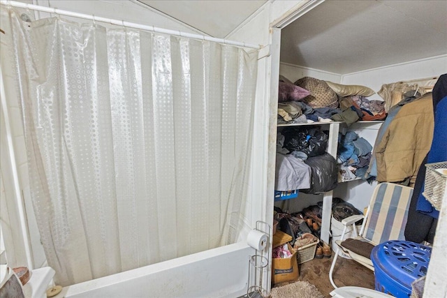 interior space featuring hardwood / wood-style floors, vaulted ceiling, and shower / tub combo with curtain