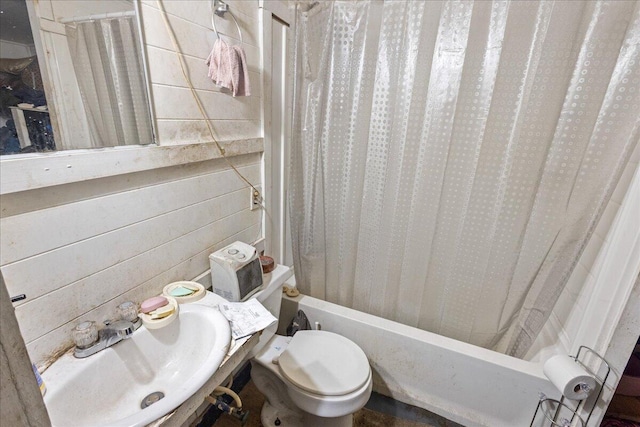 full bathroom with wooden walls, sink, shower / bathtub combination with curtain, and toilet