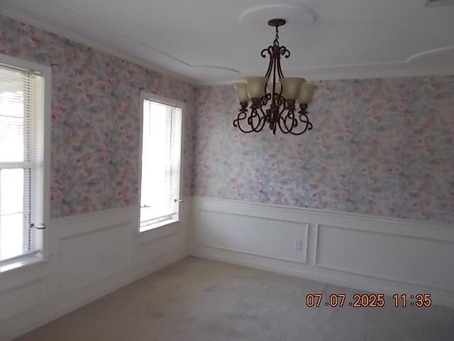 3938 Crest Dr, Hephzibah, GA 30815 - unfurnished dining area featuring a chandelier, wainscoting, wallpapered walls, and healthy amount of natural light