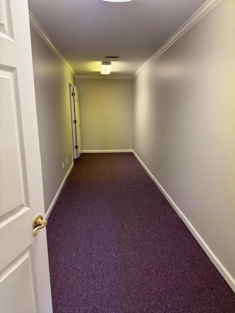 corridor featuring ornamental molding and dark colored carpet