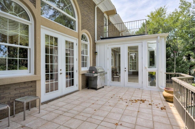 view of patio with a balcony, area for grilling, and french doors