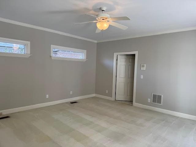 carpeted spare room with crown molding and ceiling fan