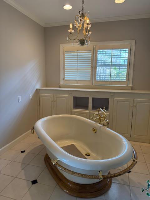 bathroom with ornamental molding, a chandelier, and tile patterned flooring