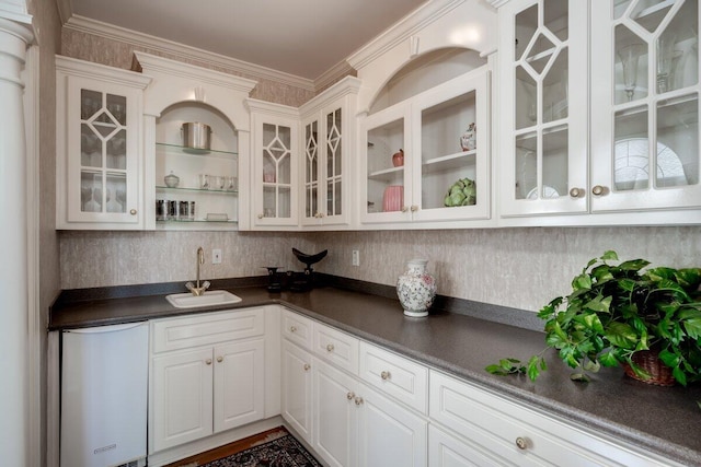 bar featuring dishwasher, white cabinetry, sink, and ornamental molding