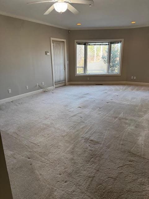 carpeted empty room with crown molding and ceiling fan