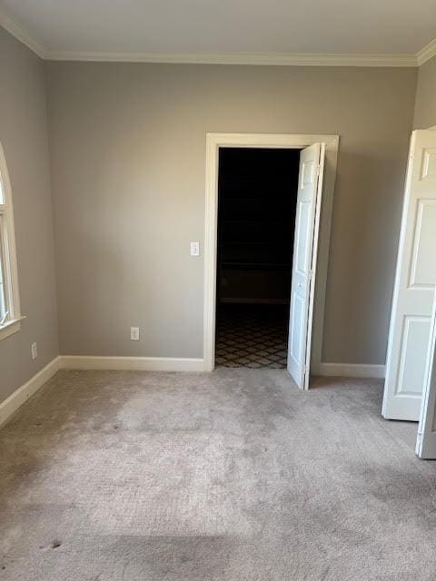 unfurnished room with crown molding and light colored carpet