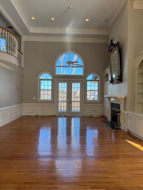 unfurnished living room featuring hardwood / wood-style flooring, a healthy amount of sunlight, and french doors