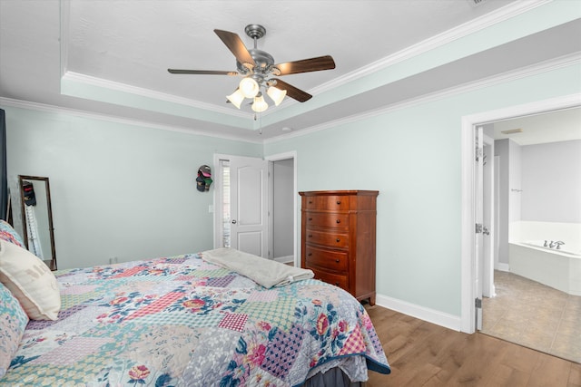 bedroom with wood finished floors, baseboards, ceiling fan, crown molding, and a raised ceiling