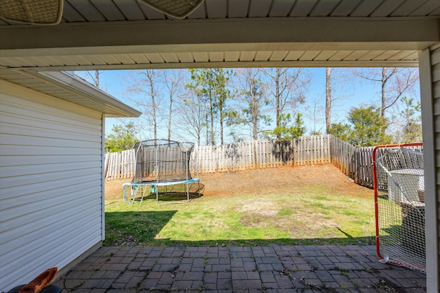 view of yard with a patio, a trampoline, and a fenced backyard