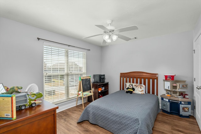 bedroom featuring visible vents, a ceiling fan, and wood finished floors