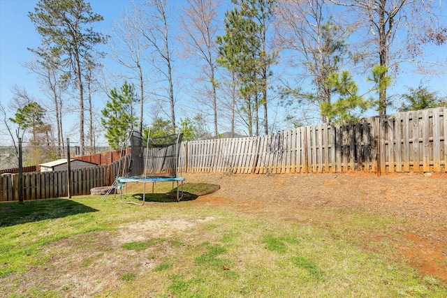 view of yard featuring a trampoline and a fenced backyard