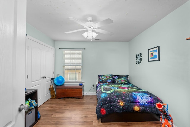 bedroom with visible vents, baseboards, ceiling fan, and wood finished floors