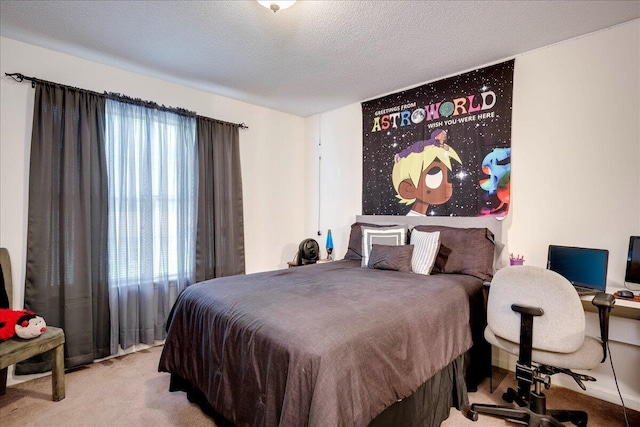 carpeted bedroom featuring multiple windows, an office area, and a textured ceiling