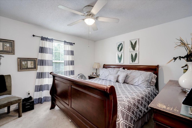 bedroom with light colored carpet, a textured ceiling, and a ceiling fan
