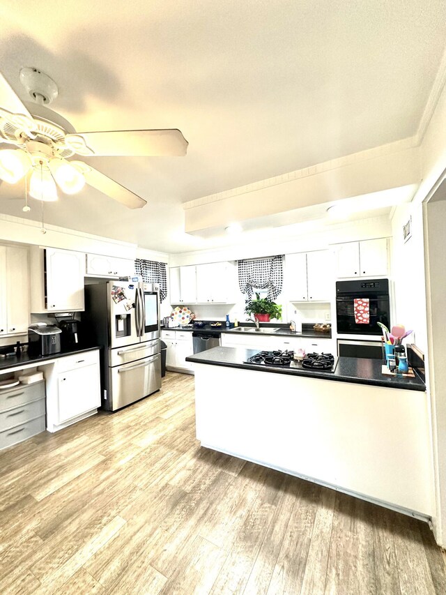 kitchen with sink, ceiling fan, light wood-type flooring, white cabinetry, and stainless steel appliances