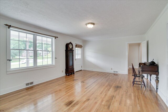 living room featuring ornamental molding, a textured ceiling, and hardwood / wood-style flooring