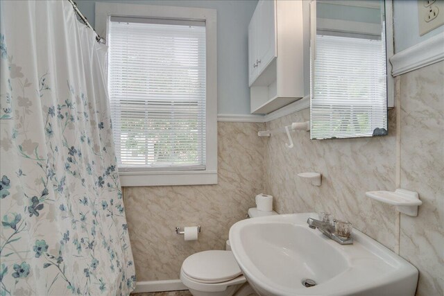 bathroom with sink, a shower with shower curtain, and toilet