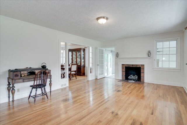 living room featuring a fireplace, wood-type flooring, and a textured ceiling