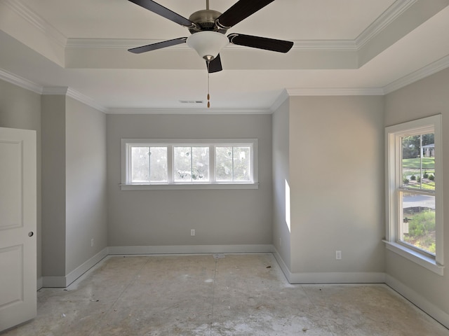 empty room with ceiling fan, a raised ceiling, and ornamental molding