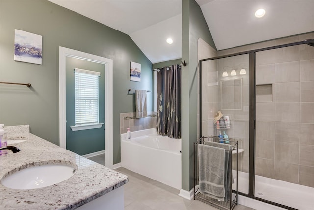 bathroom with a shower stall, a sink, double vanity, vaulted ceiling, and a garden tub