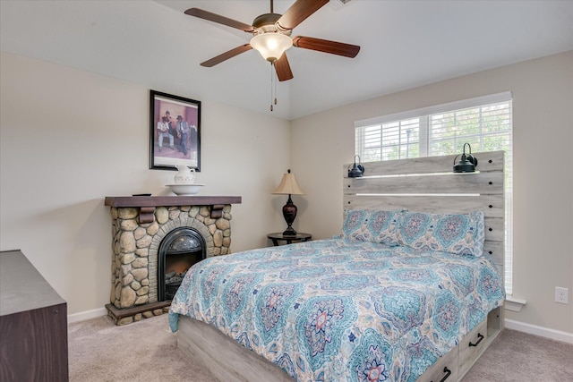 bedroom featuring a fireplace, ceiling fan, baseboards, and carpet floors
