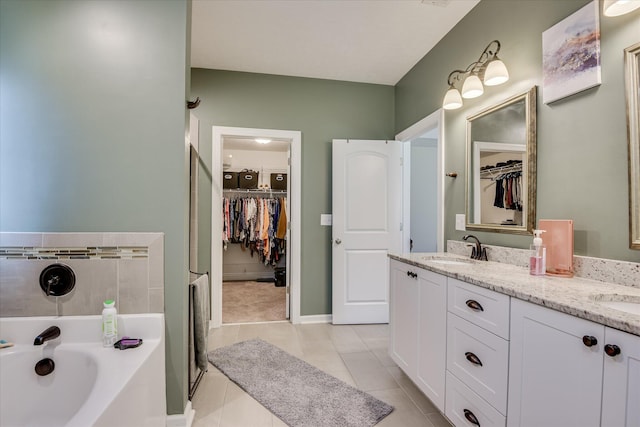 full bath featuring a sink, a bath, double vanity, tile patterned flooring, and a spacious closet