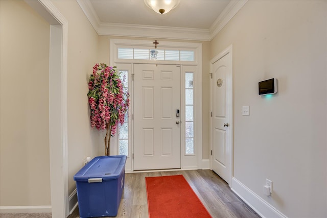 entrance foyer with wood finished floors, crown molding, and baseboards