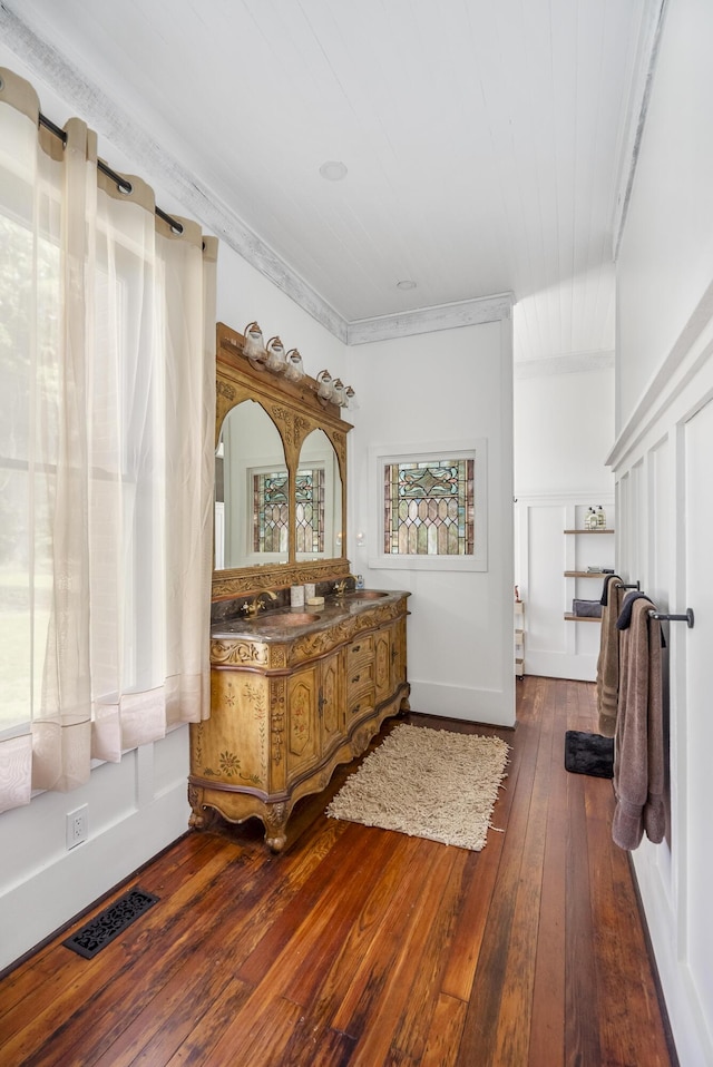 bathroom featuring vanity, wood-type flooring, and crown molding