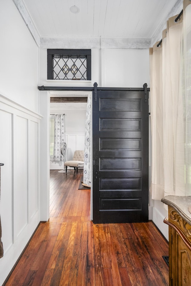 interior space with a barn door and dark wood-type flooring