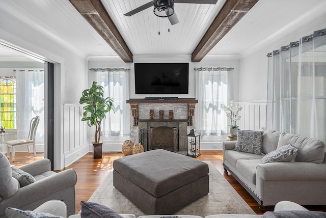 living room with beamed ceiling, a healthy amount of sunlight, and hardwood / wood-style flooring