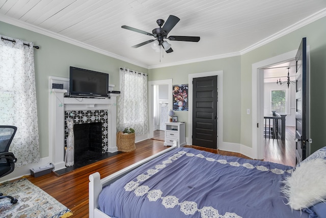 bedroom with ceiling fan, dark hardwood / wood-style floors, ornamental molding, and a fireplace