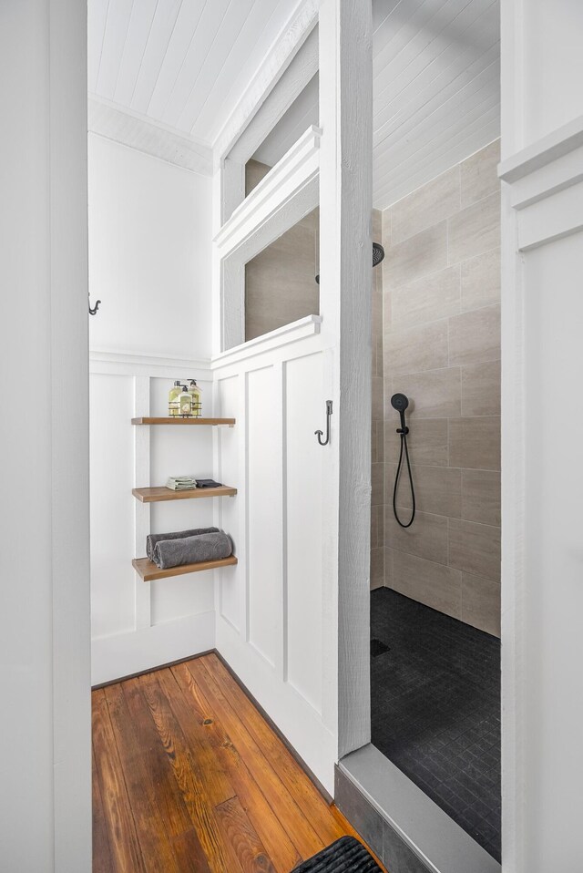 bathroom featuring tiled shower and wood-type flooring