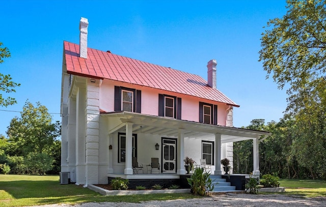 view of front of property with a front yard, a porch, and central AC unit