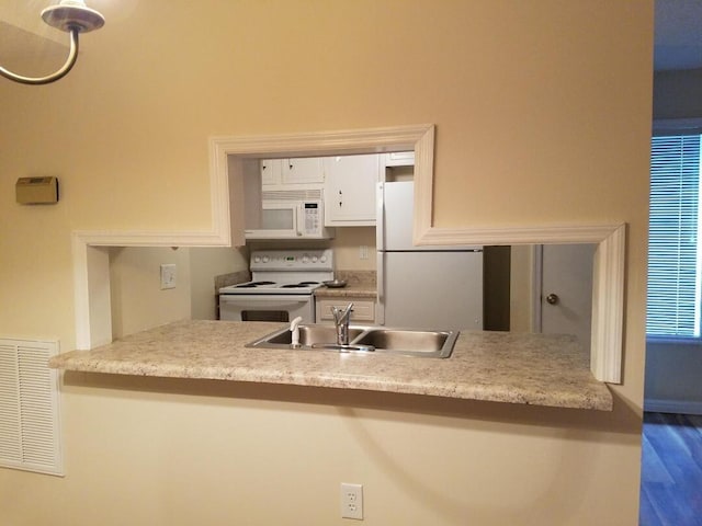 kitchen with sink, white appliances, and white cabinets