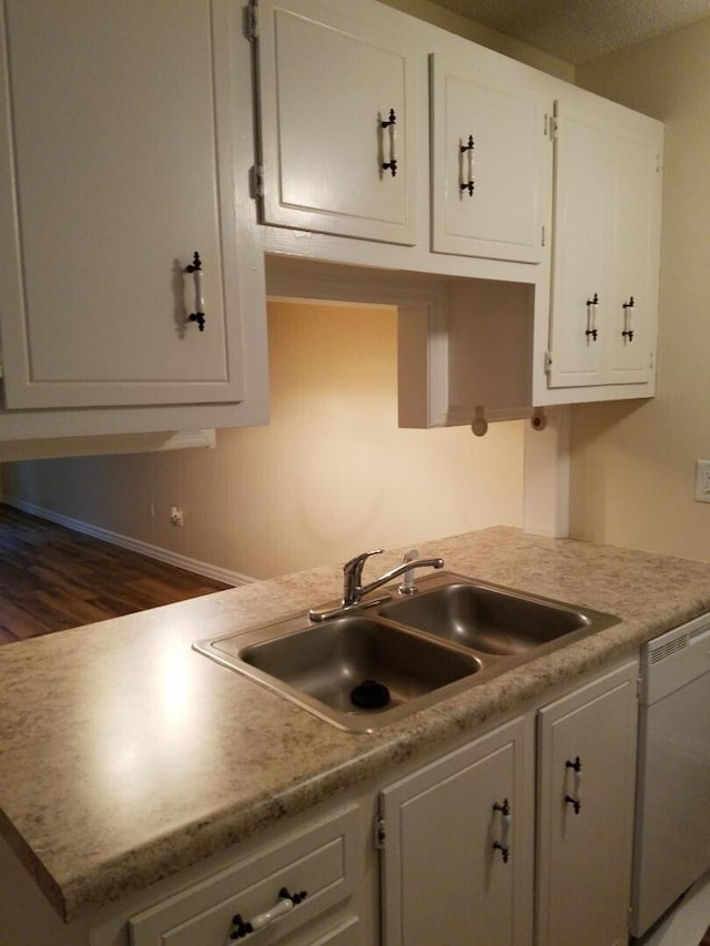 kitchen with sink, white cabinetry, dark hardwood / wood-style floors, and dishwasher