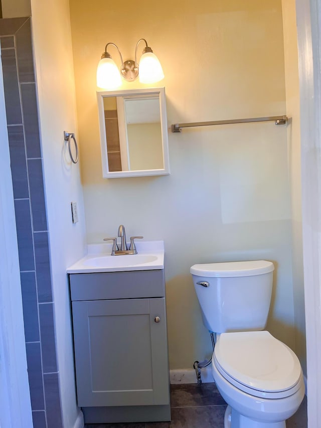 bathroom with baseboards, vanity, and toilet