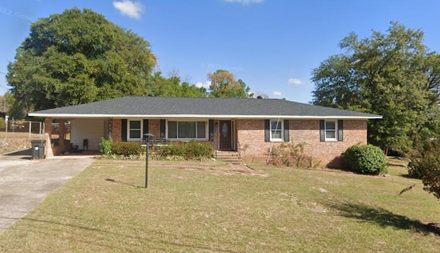 single story home featuring driveway, a front lawn, and brick siding